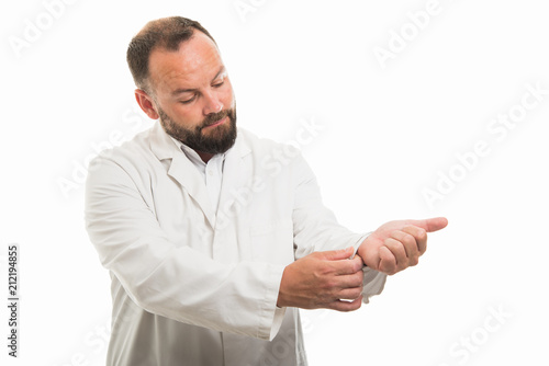 Portrait of male doctor arranging his sleeve