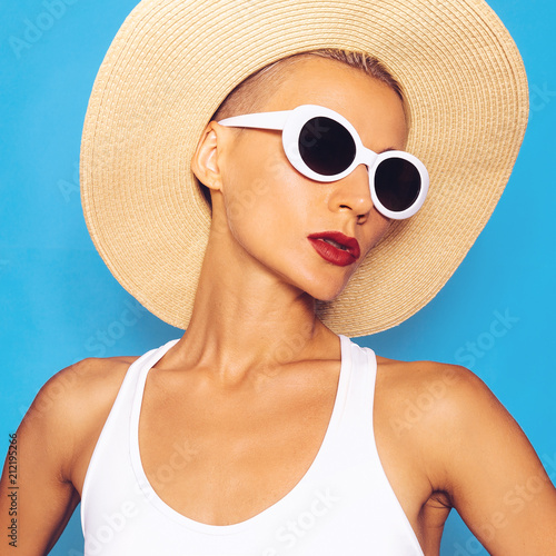 Beach fashion. Glamorous Model in beach accessories. Hat and sunglasses. White Holiday style