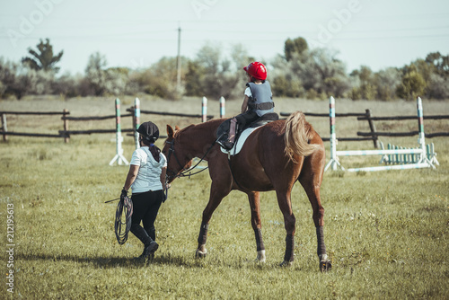 A little girl is learning to ride a horse.