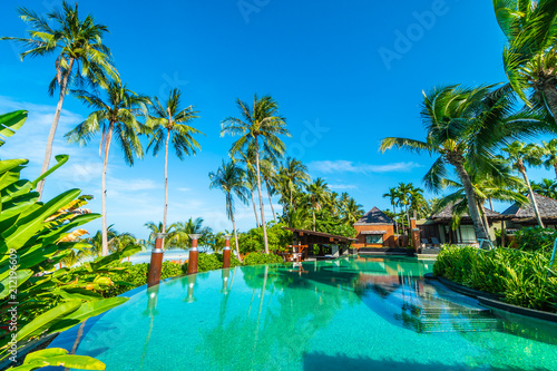 Beautiful outdoor swimming pool with coconut palm tree © siraphol