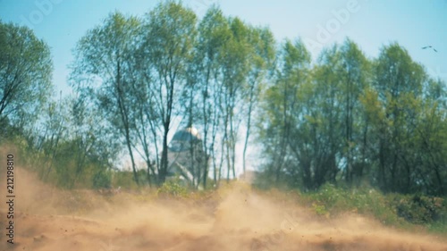 Motorbike is racing across sandy terrain in slow motion photo