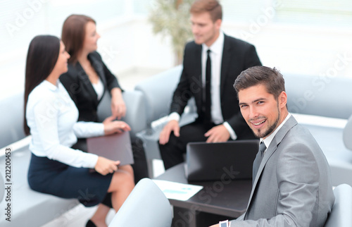 businessman sitting in an office on the background of business team.