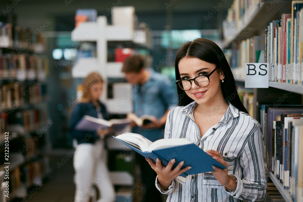Girl Reading Book In Library. Student Learning Girl Reading Book In Library. Student Learning