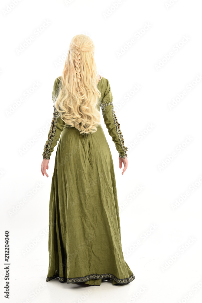 Fototapeta premium full length portrait of blonde girl wearing green medieval gown, standing pose facing away from camera. isolated on white studio background.