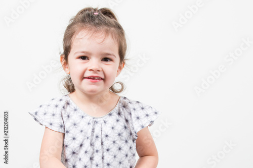 Adorable smiling little girl sitting on floor isolated on a white
