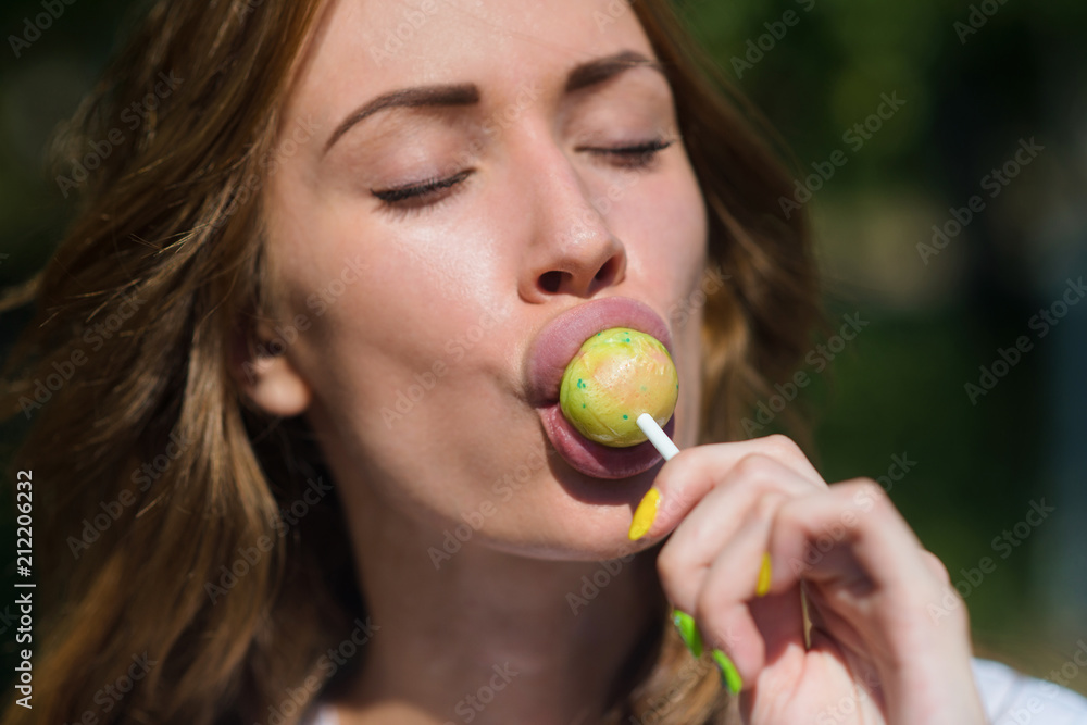 Beautiful girl sucks Lollipop in summer outdoors Beautiful girl sucks Lollipop in summer outdoors