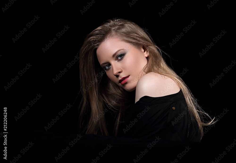 Sexy glamour female model with long blond hair posing in black shirt on dark background with red lipstick. Art portrait. Sexy glamour female model with long blond hair posing in black shirt on dark background with red lipstick. Art portrait.