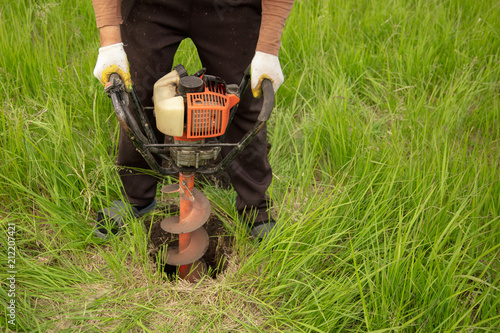 Worker drills the ground at the construction site