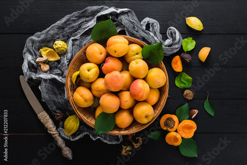 Sweet ripe apricots on black wooden background. Copy space