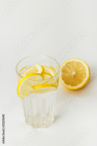  Refreshing water with lemon in a glass on a white background on a hot day