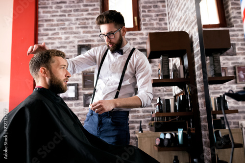 Hairdresser adjusts hair a customer