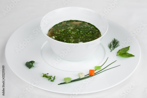 Green vegetarian soup in a white plate.