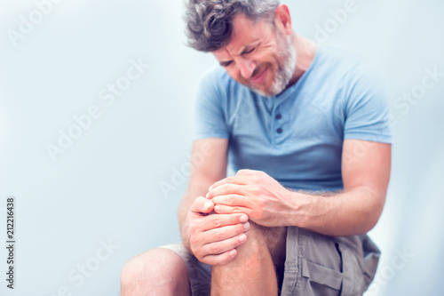 Принти на полотні Closeup man hand holding knee with pain on bed, health care and medical concept