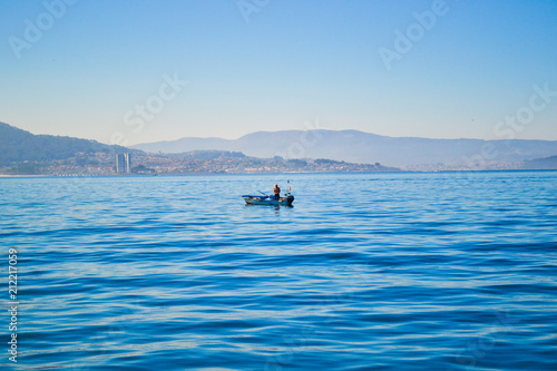 Fisherman fishing in a boat in middle of sea, Loneliness