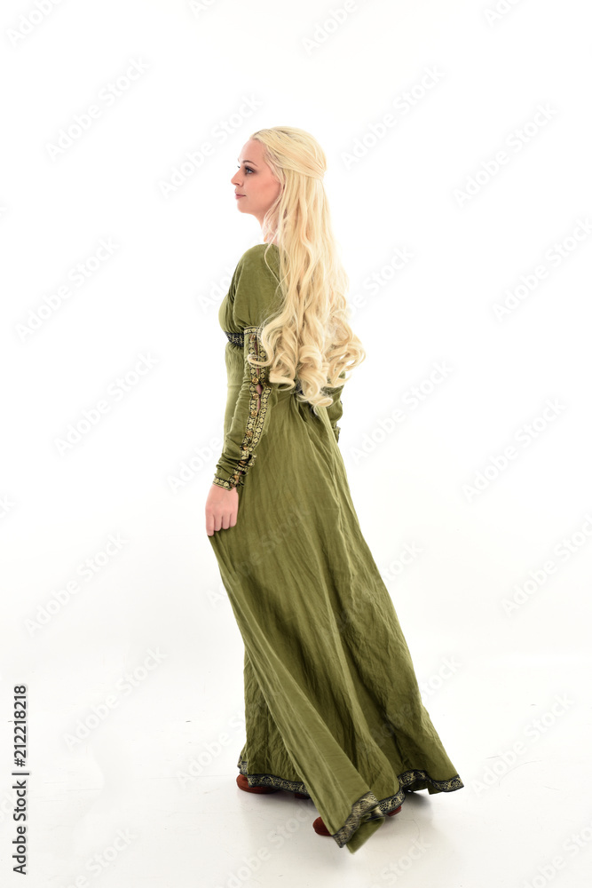 full length portrait of blonde girl wearing green medieval gown, standing pose facing away from camera. isolated on white studio background. full length portrait of blonde girl wearing green medieval gown, standing pose facing away from camera. isolated on white studio background.