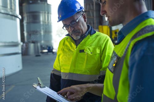 Engineers in industrial plant discussing work