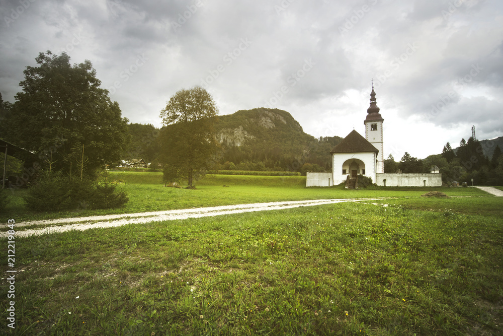 slovenian church in the evening, sun light over the church and the lawn, slovenia state's landmark, typical view for this state