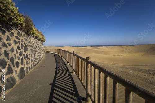 maspalomas dunes  gran canaria  spain - summer evening time  wind is blowing the sand up  sunset and golden hour  dunes  perfect time  end of sunny day