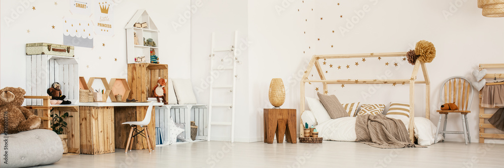Panoramic photo of a child's bedroom interior with wooden furniture, house bed, stool and wall stickers - obrazy, fototapety, plakaty 