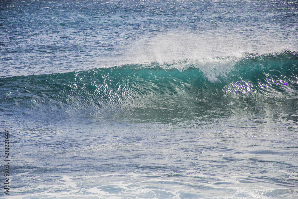 typical windy day in gran canaria, canary islands, spain. ideal for surfing, bigger waves in the sea, turquoise blue water in the ocean typical windy day in gran canaria, canary islands, spain. ideal for surfing, bigger waves in the sea, turquoise blue water in the ocean