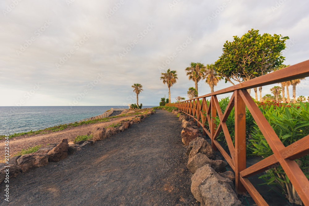 Ground path with handrails along rocky coastline.