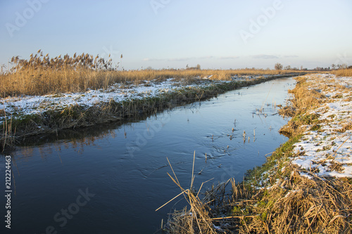 Small wild river and snow on the shore