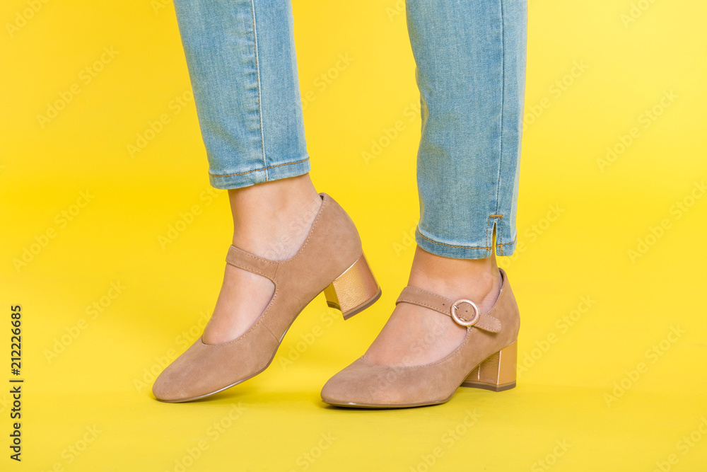 Beige Schuhe vor gelbem Hintergrund Beige Schuhe vor gelbem Hintergrund