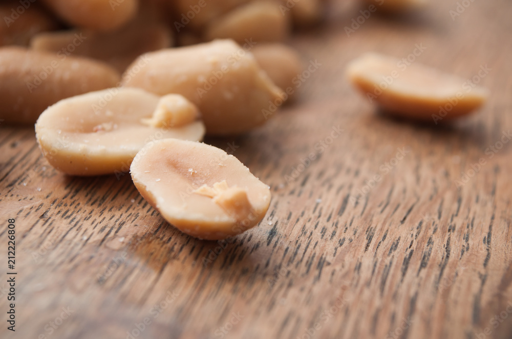closeup of salted peanuts on wooden background closeup of salted peanuts on wooden background