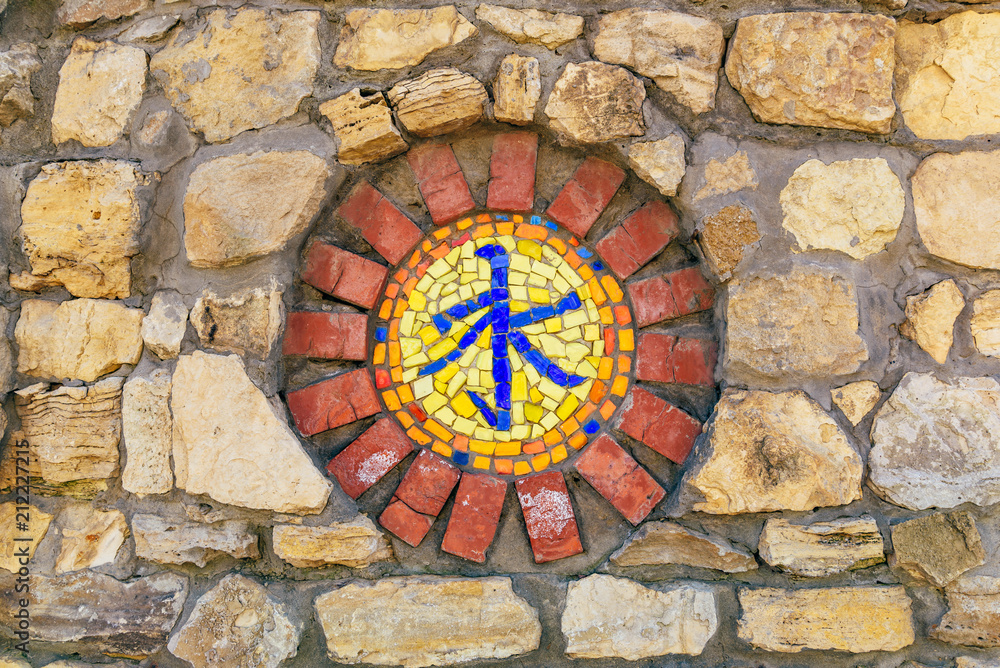Mosaic religious symbol on wall.