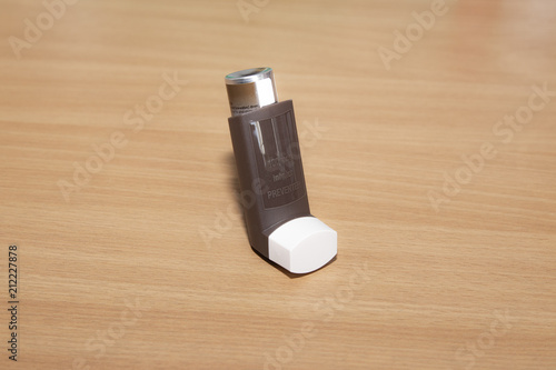 Brown preventative inhaler on a wooden table photo