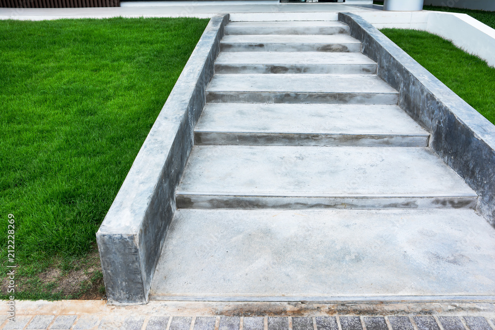 Concrete staircase at slope way beside grass field background Concrete staircase at slope way beside grass field background