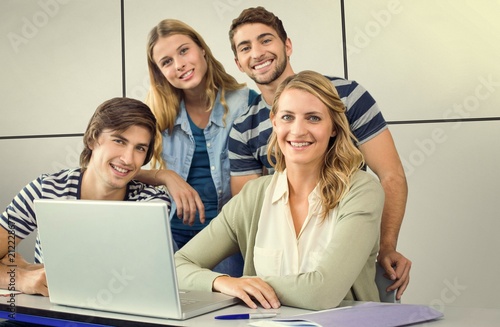 Composite image of students using laptop in classroom