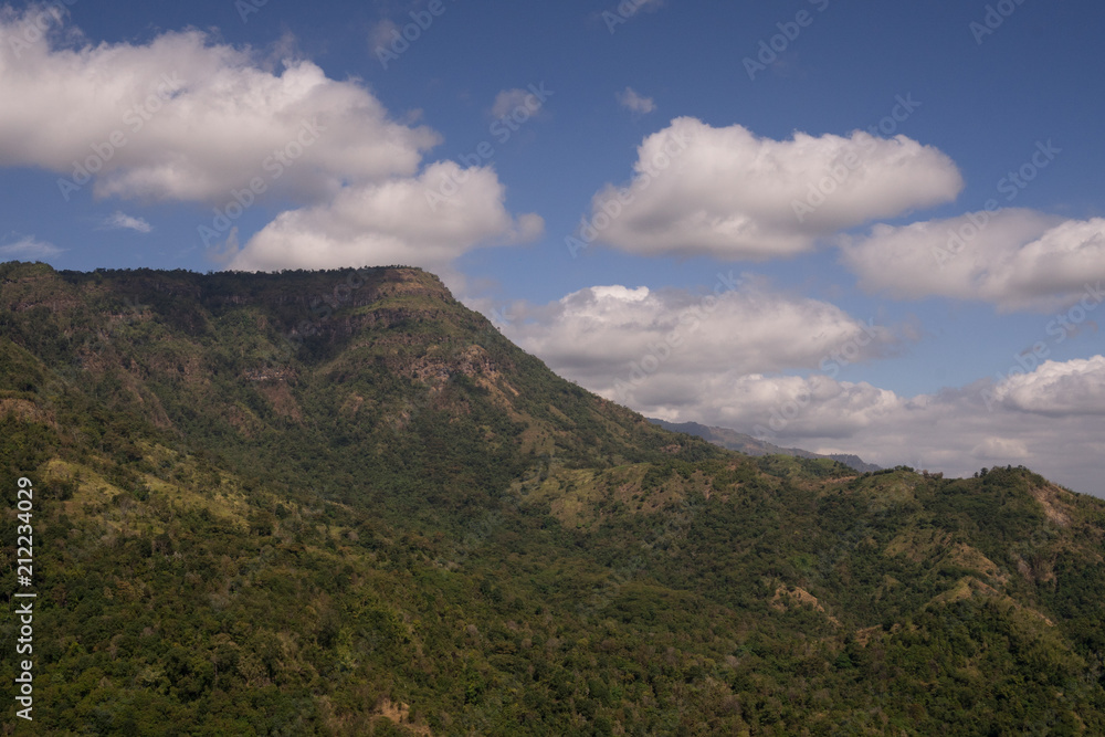 range of green mountain under cloudy blue sky