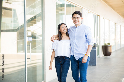 Smiling Teenage Lovers Strolling In Corridor