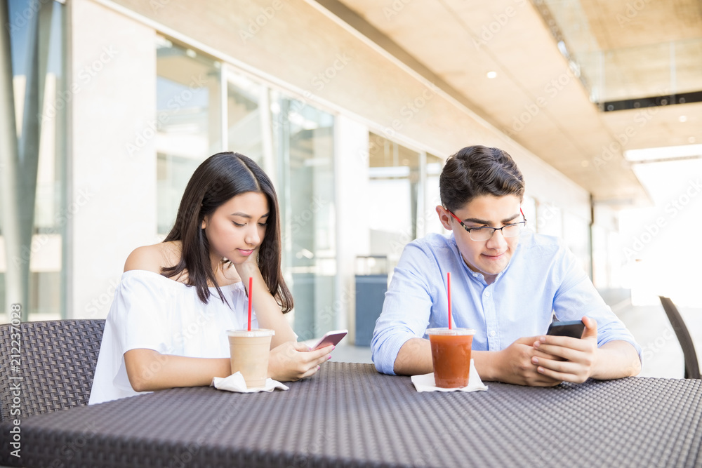Obsessed Couple Using Smartphones In Shopping Mall Obsessed Couple Using Smartphones In Shopping Mall