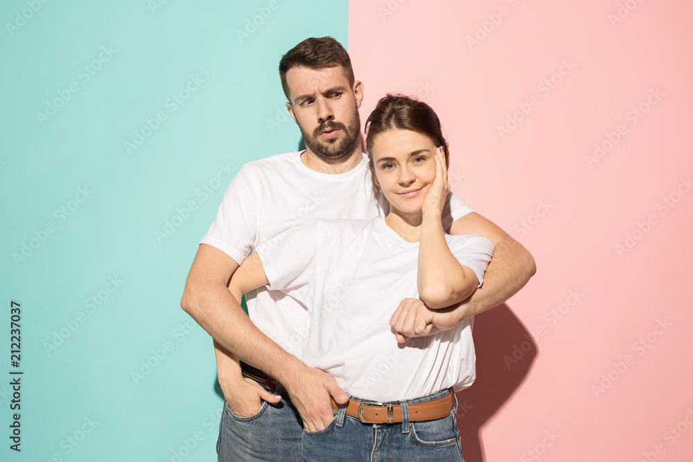 Wow. Doubtful pensive couple with thoughtful expression making choice against pink background Wow. Doubtful pensive couple with thoughtful expression making choice against pink background