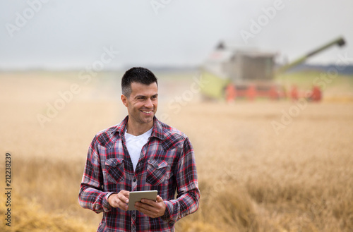 Farmer with tablet in field during harvest