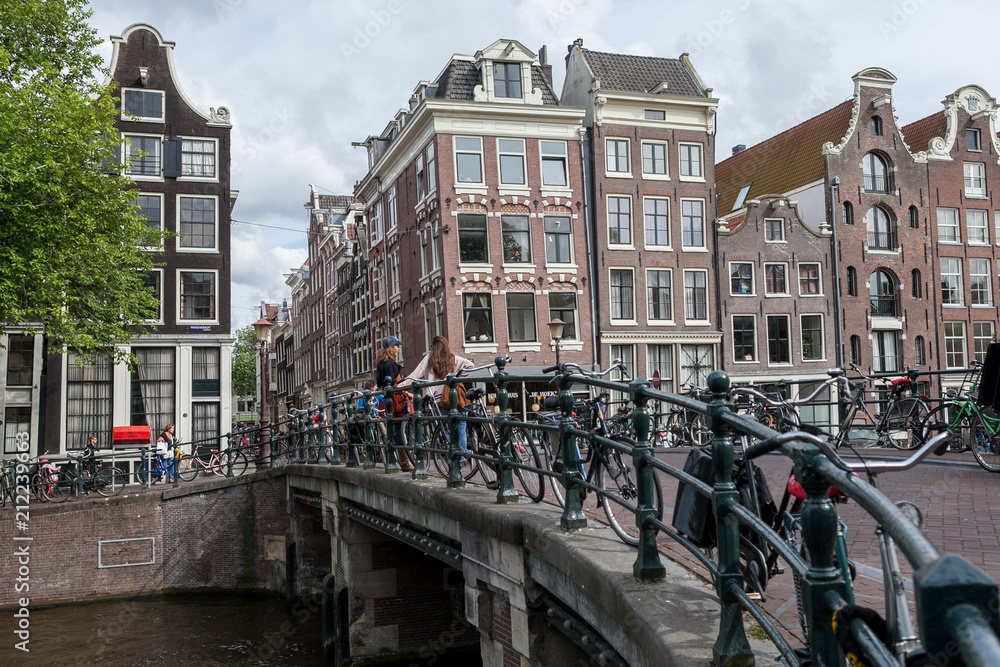 Amsterdam canal bridge with bicycles and typical canal houses