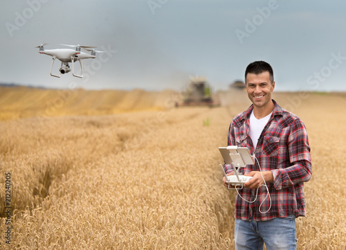 Farmer with drone in front of combine harvester