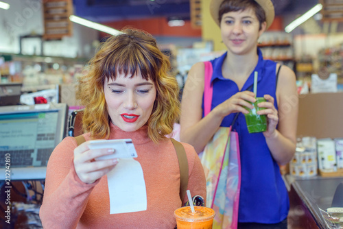 Two women in a shop paying for fresh juice  drinks photo