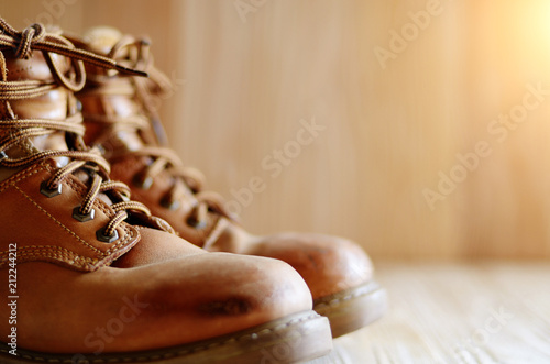 Wallpaper Mural Yellow leather used work boots on wooden background closeup. Place for text Torontodigital.ca
