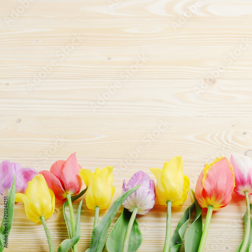 Colorful tulip flowers on wooden table background with space for text
