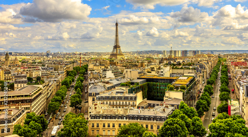 Arch of Triumph panorama from Place Charles de Gaulle square. Trees street Avenues Marceau, d'Iena and Kleber in Paris, France, Europe. Distant view of Tour Eiffel tower in Paris cloudy skyline. © bennymarty
