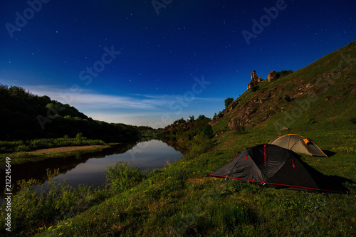 tourist tents at riverbank at summer night