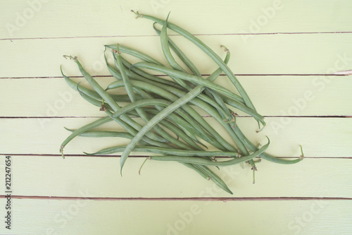 green beans on a green wooden table viewed from above