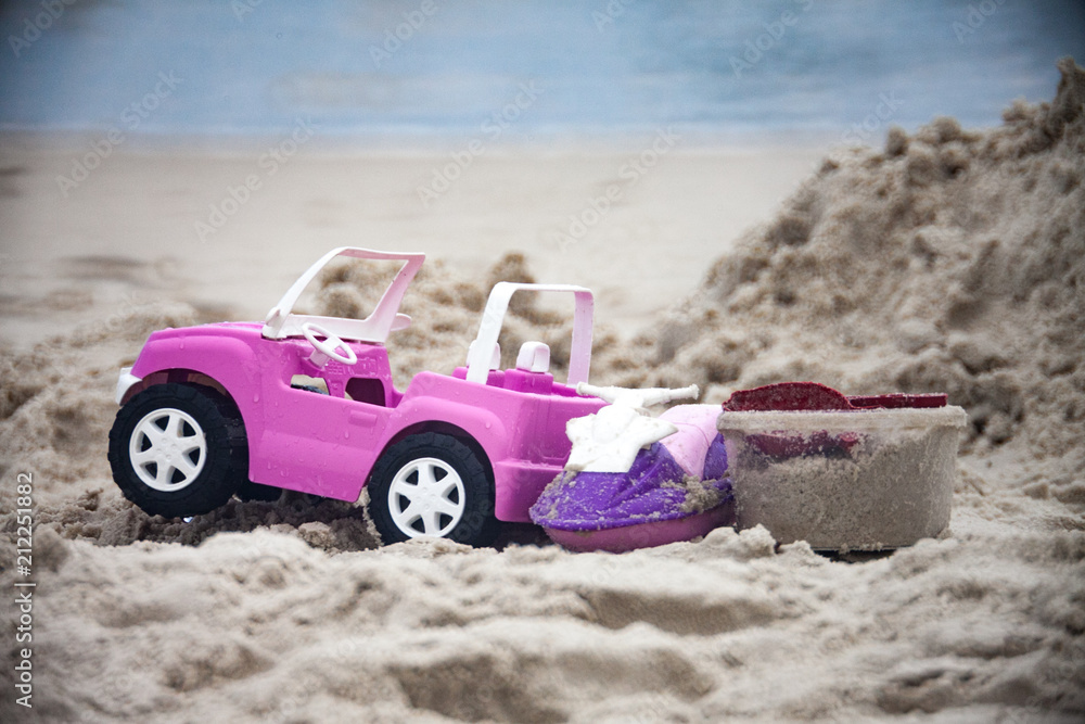 Toy car on the beach with the sea in the background Toy car on the beach with the sea in the background