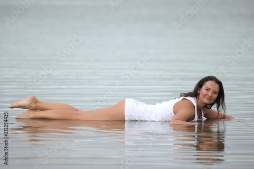 seductive young brunette in wet shirt on beach