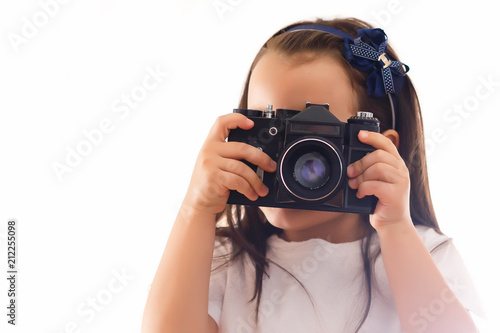 Girl taking a picture with a professional retro camera isolated on white