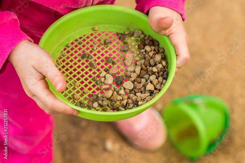 Canvas Print The child is playing in the sandbox. Children's hands.