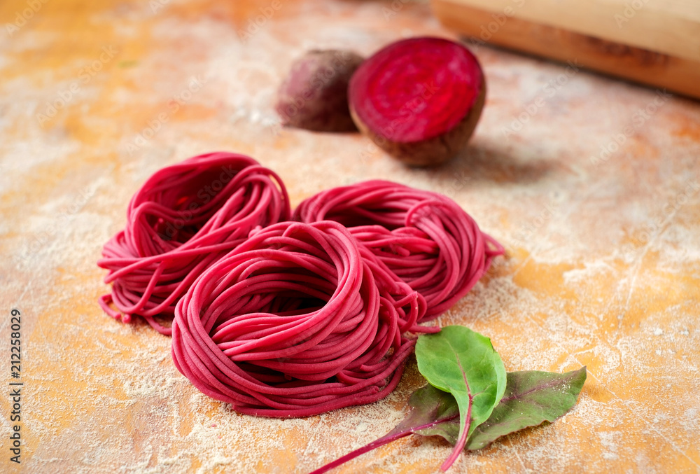 hand made beetroot pasta nest on a wooden table